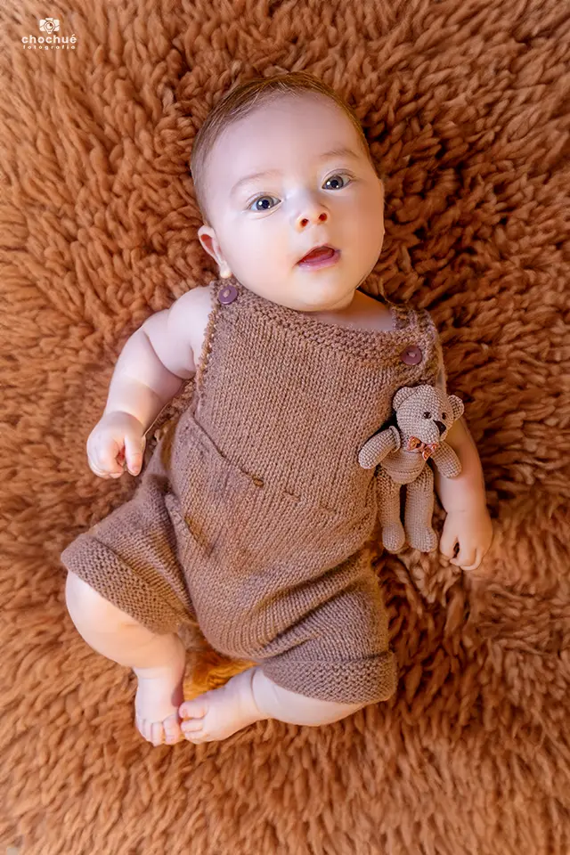 Bebé de meses recostado con ropa tejida café, sesión mes a mes