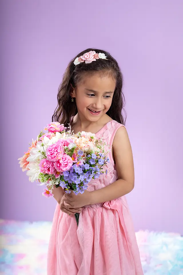 Niña sonriente con ramo de flores, sesión para niños y niñas